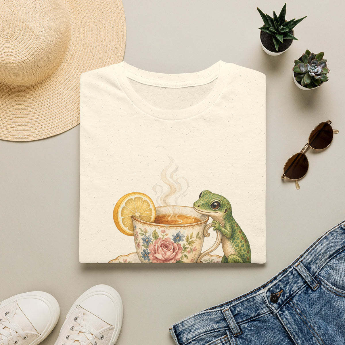 Tea Time Gecko cottagecore watercolor T-shirt from Gold Gecko Co. — gecko sipping from a floral teacup among daisies and lavender.